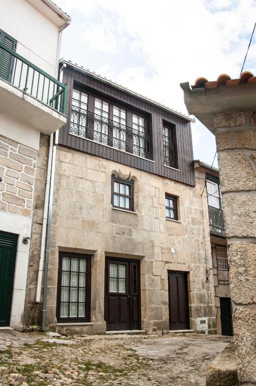 an old stone building with windows and a balcony at Casa dos Limos Verdes in Folgosinho