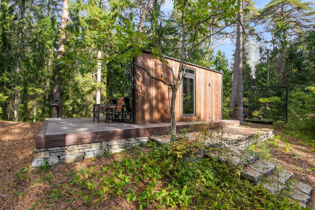 een klein huisje in het bos met een terras bij ÖÖD Hötels Rannamõisa - with sauna in Rannamõisa