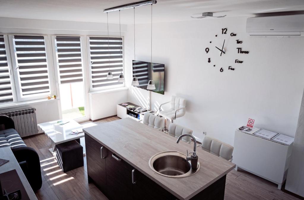 una cocina con fregadero y un reloj en la pared en Treba Malo Odmorit - Family Room, PS4 Pro, Free parking, en Karlovac