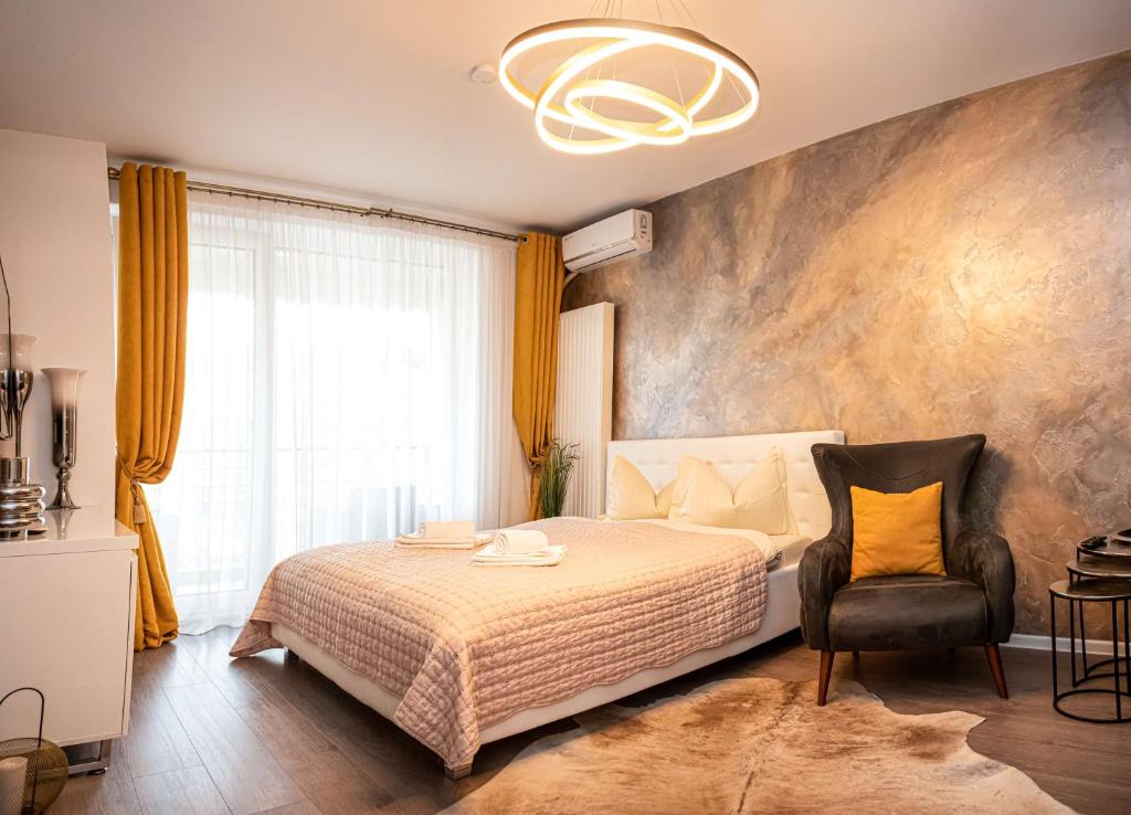 um quarto com uma cama e uma cadeira em Royal Apartment em Brasov