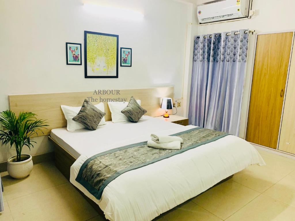 - une chambre avec un grand lit dans l'établissement ARBOUR The Homestay, à Guwahati