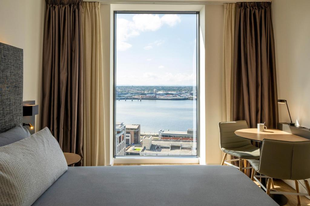 a bedroom with a large window with a view of the water at INNSiDE by Meliá Liverpool in Liverpool