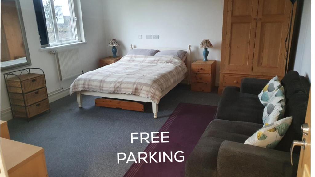 a bedroom with a bed and a couch at Dan's Homestay in Bristol