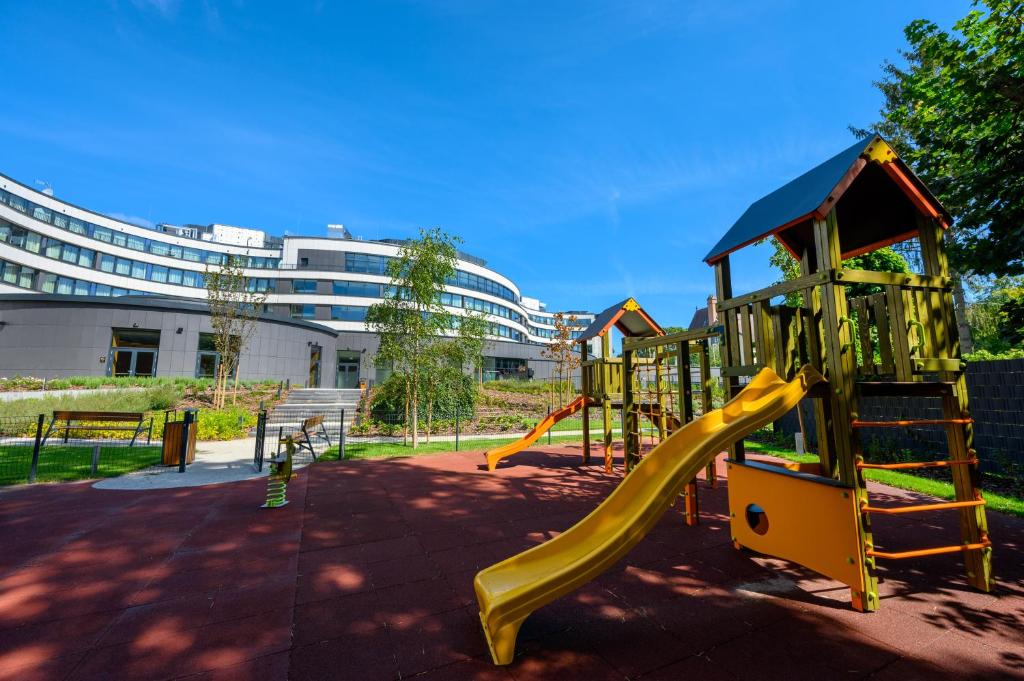 a playground with a yellow slide in a park at Grand Hotel Esztergom in Esztergom