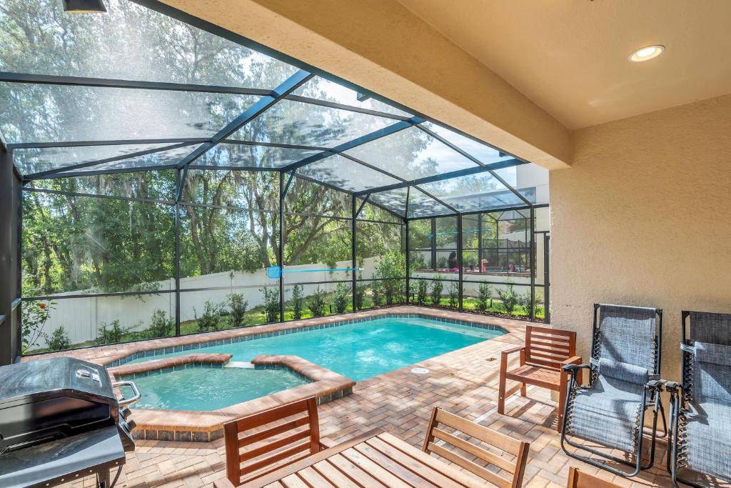 a swimming pool in a house with a large window at Private Pool Villa, FREE Water Park, Near Disney in Kissimmee