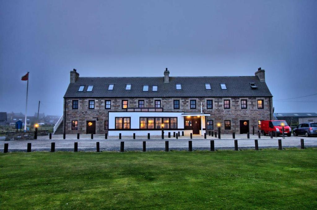 布里村的住宿－The Sands Hotel, Orkney，前面有草坪的大型砖砌建筑