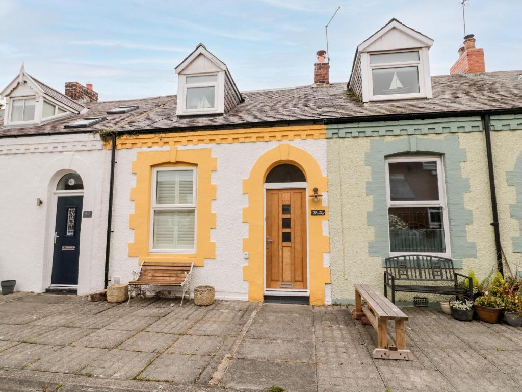 ein Haus mit einer Bank davor in der Unterkunft Bay Cottage in North Shields