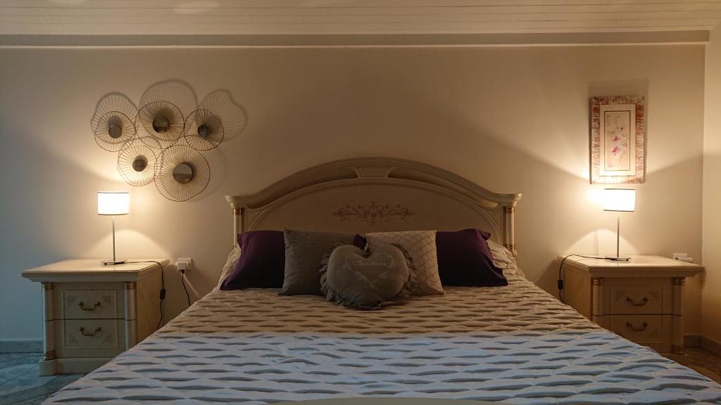 a bedroom with a large bed with two night stands at Le Domaine des Tuillieres in Masléon