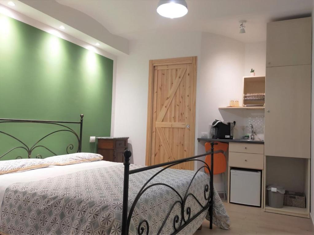 ein Schlafzimmer mit einem Bett und einer grünen Wand in der Unterkunft Antico Portale Ospitalità Diffusa in Acquasparta