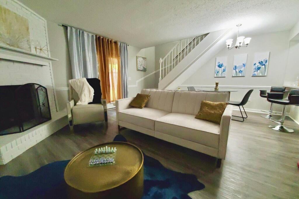 uma sala de estar com um sofá e uma televisão em Modern Designer Townhouse 2Br Ideal for Long Stays! em Jackson