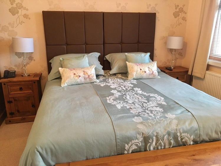una camera da letto con un grande letto con due comodini di Chaston Manor Hotel a Sandown