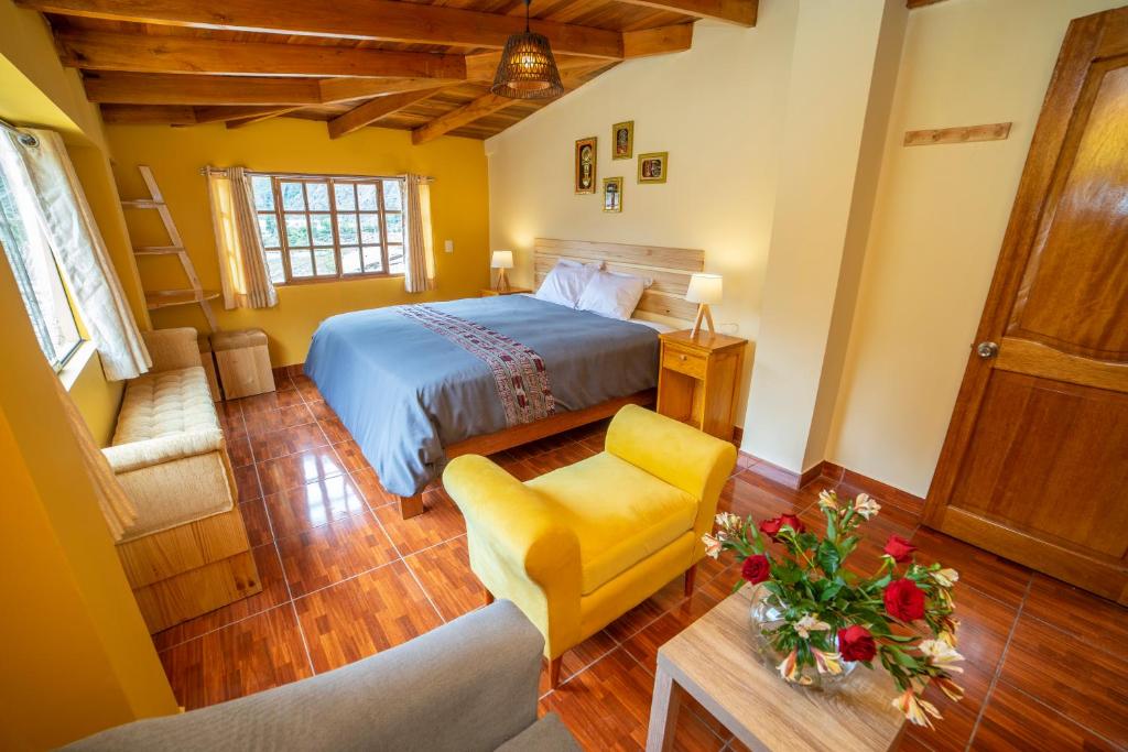 a bedroom with a bed and a chair and a table at San Isidro's House in Ollantaytambo