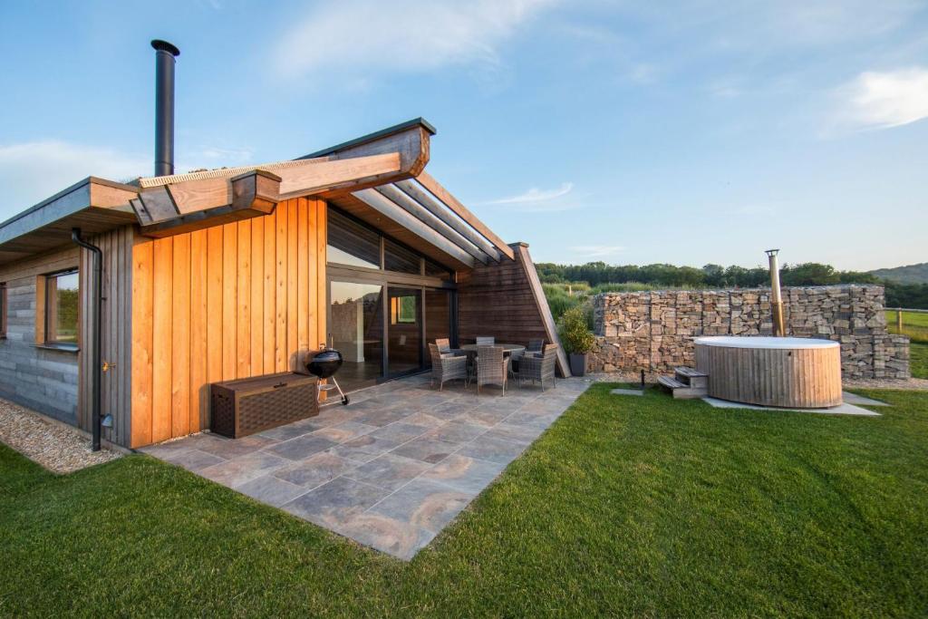a small house with a patio and a grill at Dorset Eco Retreats in Ansty