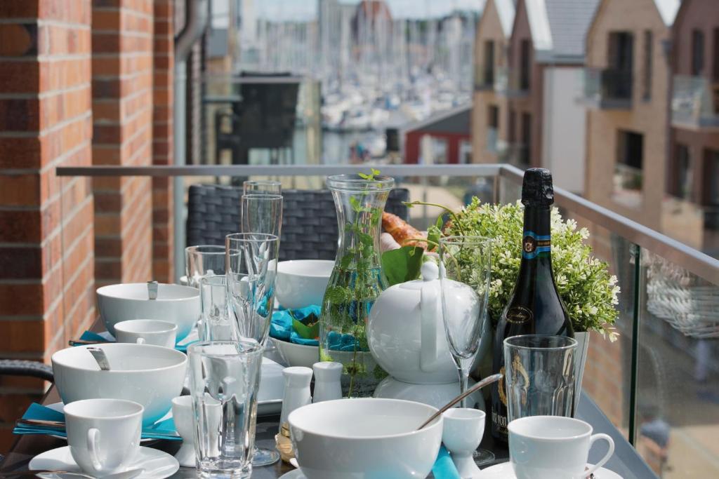 a table with glasses and wine bottles on a balcony at Ostsee - Appartement Nr 82 "MeerGlück" im Strand Resort in Heiligenhafen
