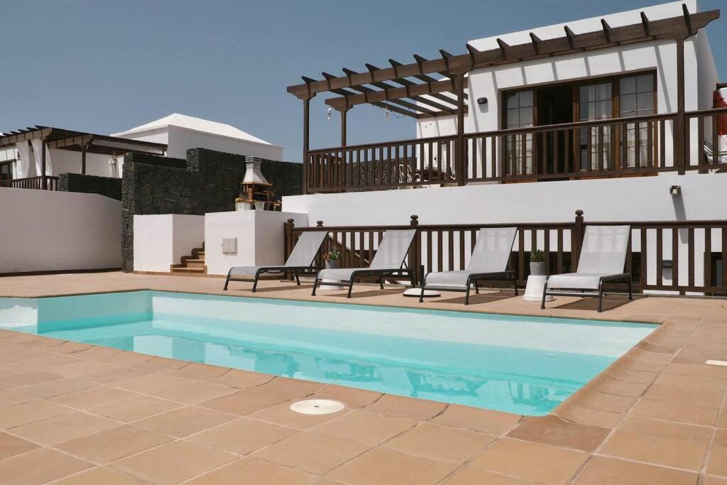 a swimming pool in front of a house at CASA MOCI in Playa Blanca