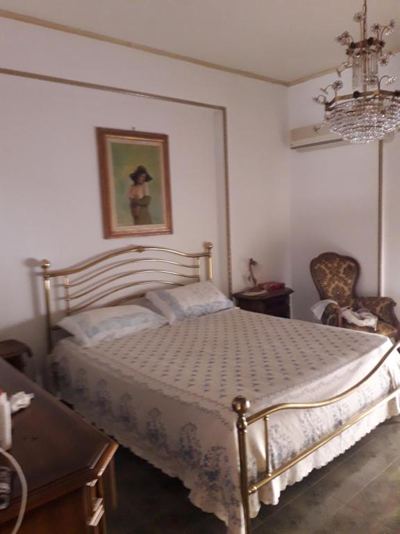 Schlafzimmer mit einem Bett und einem Kronleuchter in der Unterkunft Sicilia vacanze long beach Mondello in Palermo
