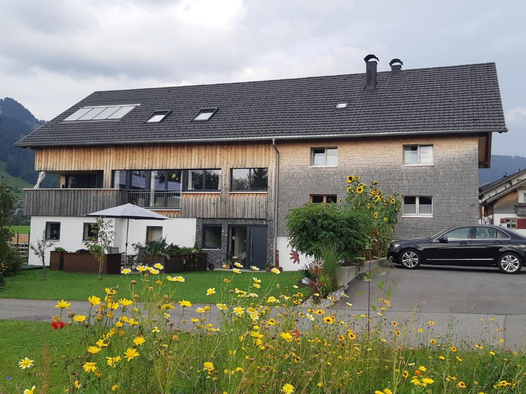 uma casa com um carro estacionado em frente em Ferienwohnung Gmeiner em Hittisau