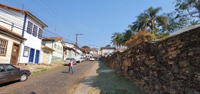 uma criança a andar numa rua ao lado de uma parede de pedra em Apart Hotel Flomon em Ouro Preto