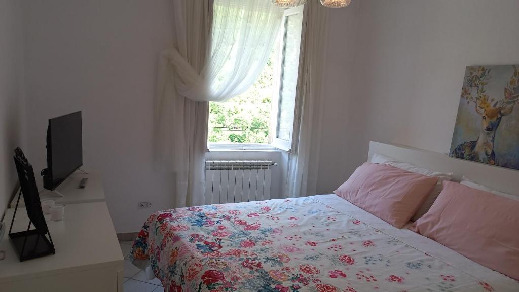 a bedroom with a bed with a floral bedspread and a window at Scanno in Scanno