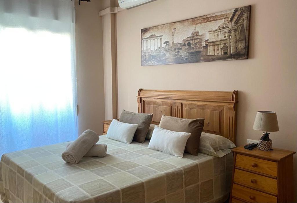 Un dormitorio con una cama con almohadas. en Apartamento Turistico San Cristobal, en Plasencia