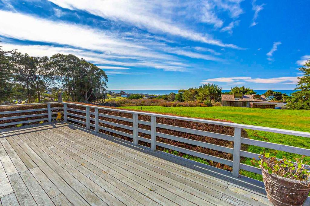 a wooden deck with a fence and a field at Almost Paradise in Bodega Bay
