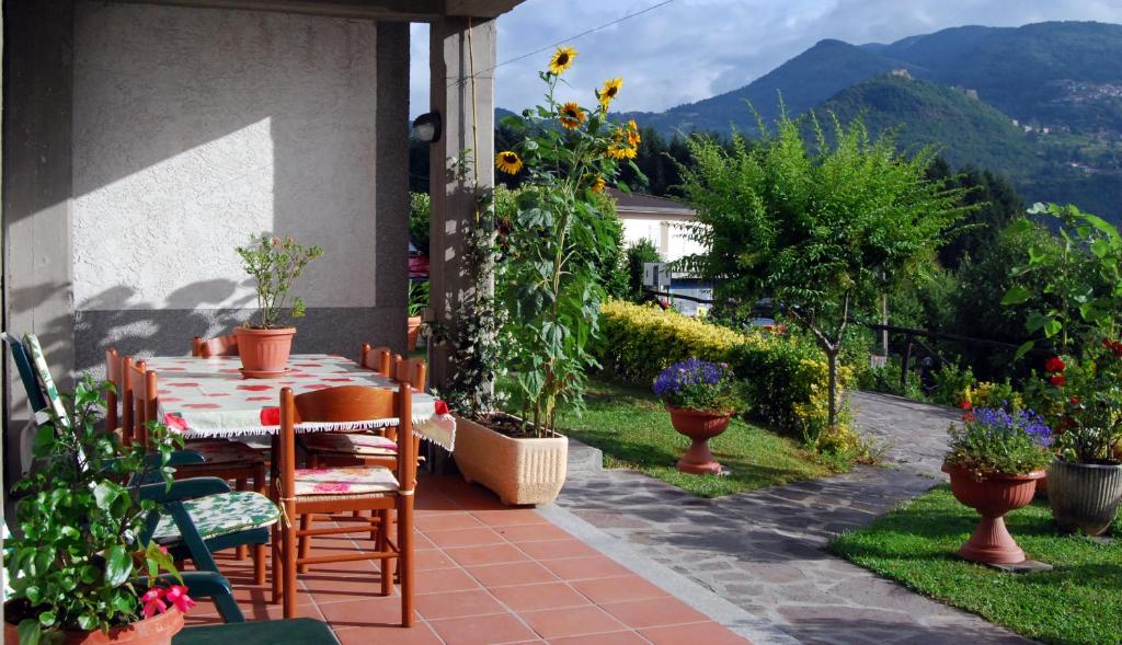 a patio with a table and chairs and flowers at B&B Da Franca in Camporgiano