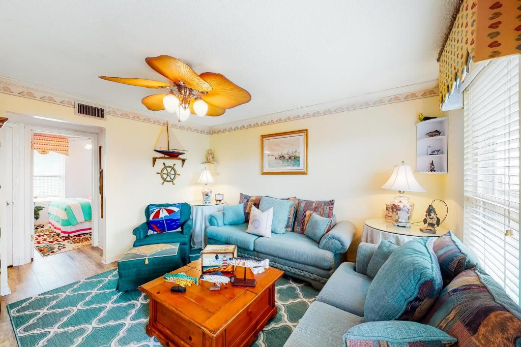 a living room with blue couches and a table at Beach Front #203 in Gulf Shores