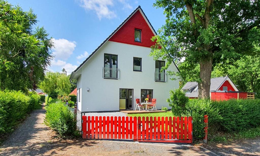 Maison rouge et blanche avec clôture rouge dans l'établissement Ferienhaus Tammy, à Göhren-Lebbin