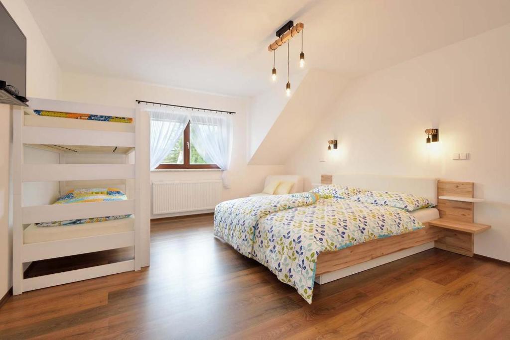 een slaapkamer met een bed en 2 stapelbedden bij PENZION Malá farma Nemojany in Nemojany