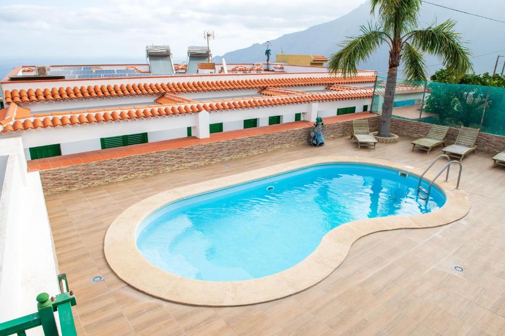 uma piscina ao lado de um edifício em Apartamentos la Palmera em Jerez de la Frontera