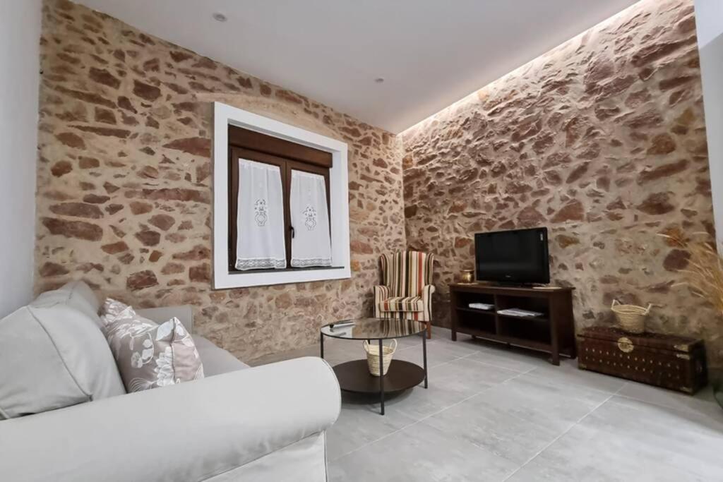 ein Wohnzimmer mit einem Sofa und einem TV in der Unterkunft Casa Pedra de Roder in Vilafames