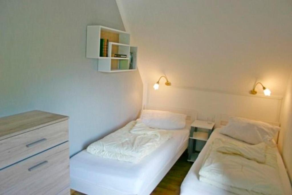 グレーミッツにあるHaus am Kurpark - Strandgutのベッド2台、デスクが備わる小さな客室です。