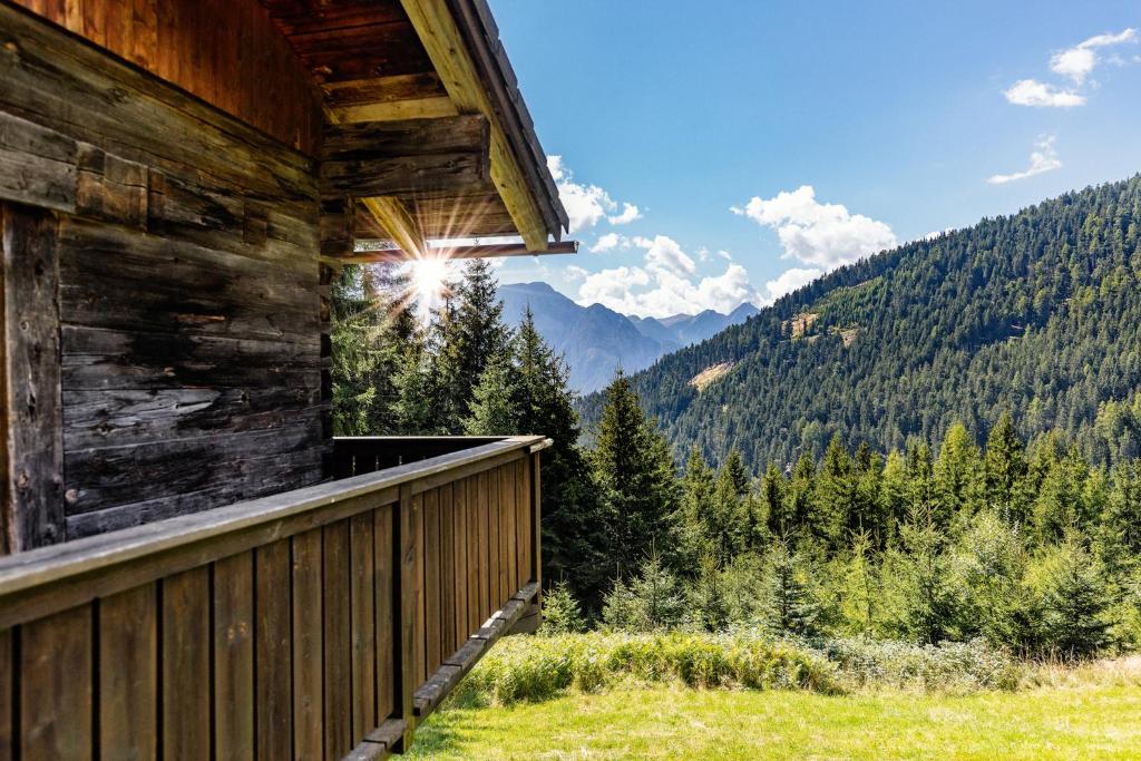 a balcony of a cabin with a view of the mountains at Fohlenwies - romantische Berghütte in Alleinlage Osttirol in Lienz