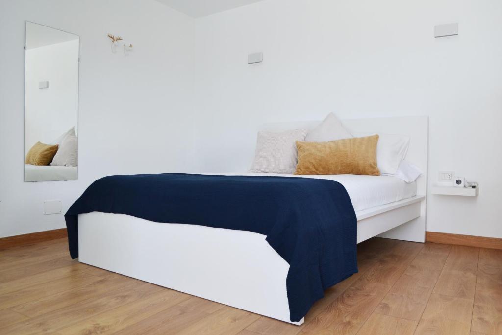 Una cama blanca con una manta azul. en Habitación con baño y entrada independiente en La Santa