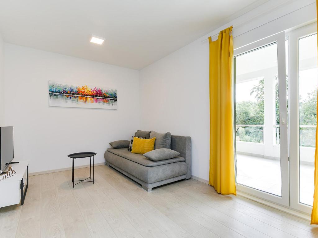 a living room with a couch and a window at Apartment Aria in Poreč