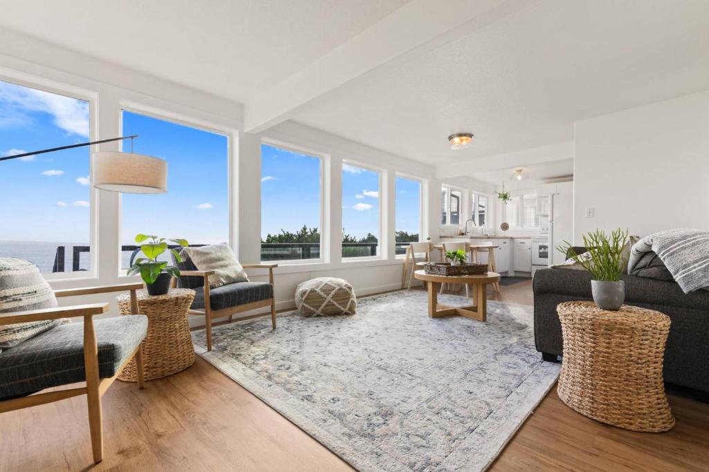 a living room with white walls and large windows at Vista House Unit B in Tillamook