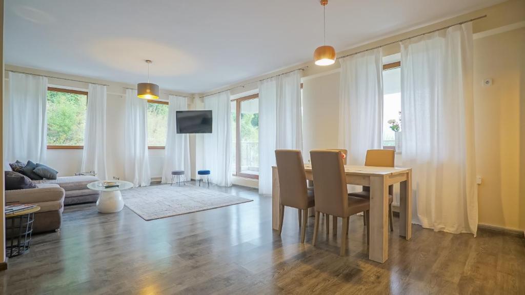 a living room with a dining room table and chairs at Coroni Apart 1 Cu Vedere Panoramica Brasov in Braşov