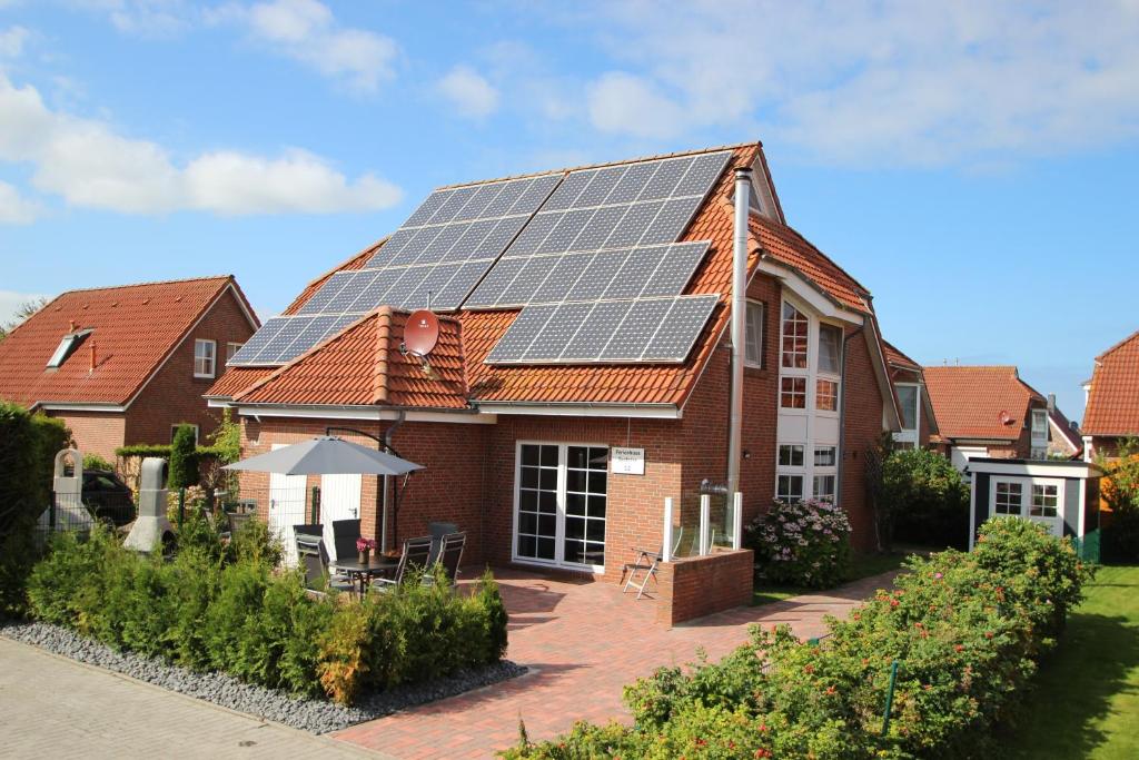 una casa con paneles solares en el techo en Ferienhaus Seebrise, en Nessmersiel