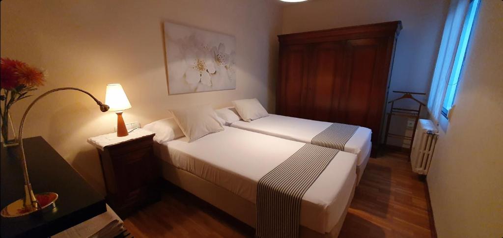 バリャドリッドにあるLa Pintadaのベッドルーム(白いベッド1台、ランプ、窓付)