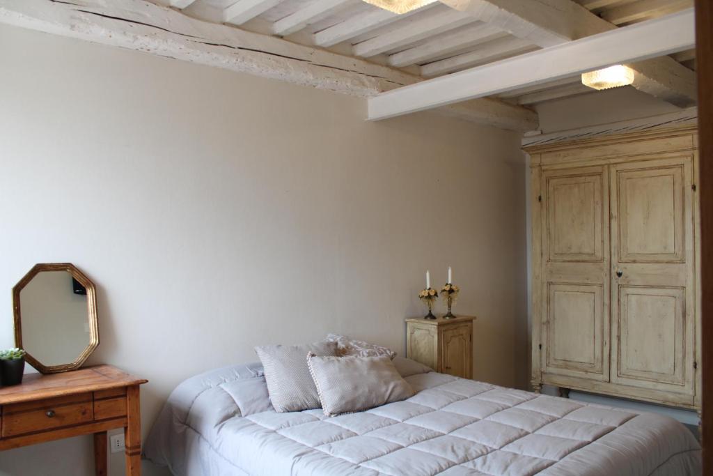 1 dormitorio con cama blanca y espejo en Una finestra sul mare - Appartamento a Fano, en Fano