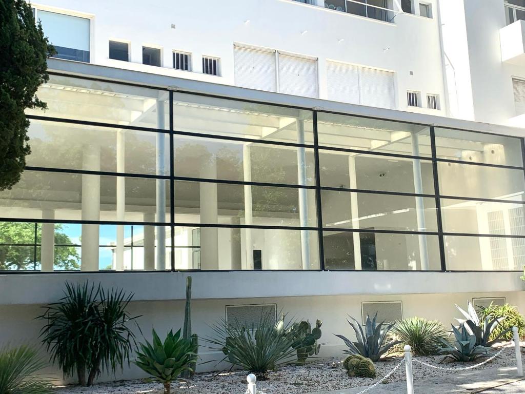 un gran edificio de cristal con plantas delante en ÉLÉGANT STUDIO et PARKING DANS BATIMENT HISTORIQUE, en Saint-Tropez