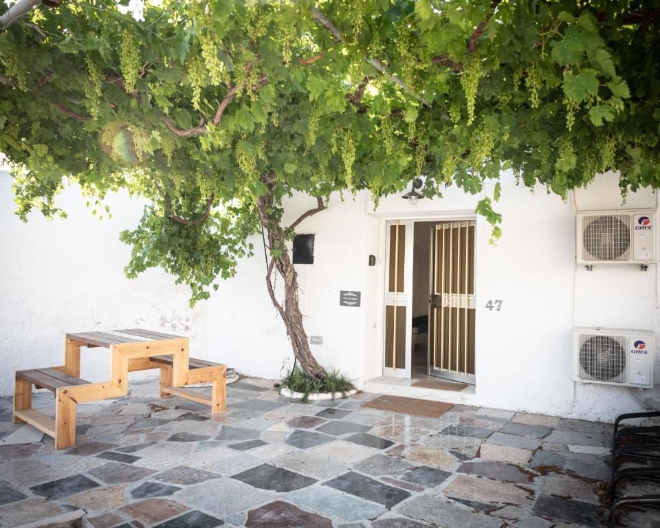 a picnic table and a tree in front of a building at LIMASSOL AKROTIRI VINE COTTAGE a in Limassol