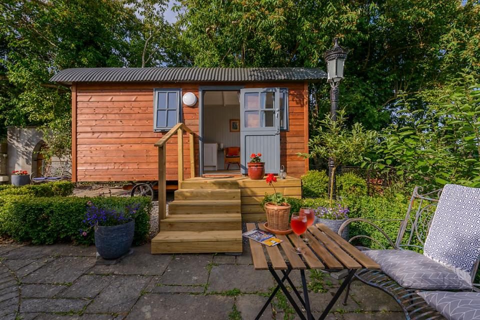 a small wooden cabin with stairs and a table at Hawthorn Hut Kilkenny Glamping at Jenkinstown House in Tower Bridge