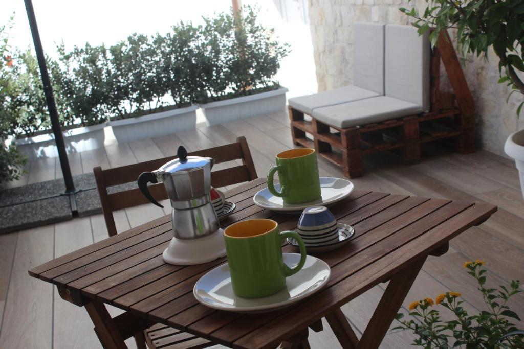 a wooden table with two coffee mugs on it at Le casette in Monopoli