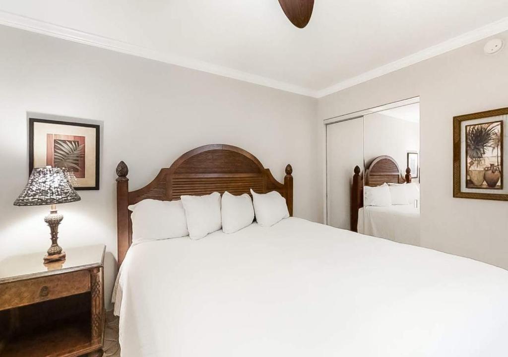 Dormitorio blanco con cama grande y lámpara en Beach House by TS, en Destin