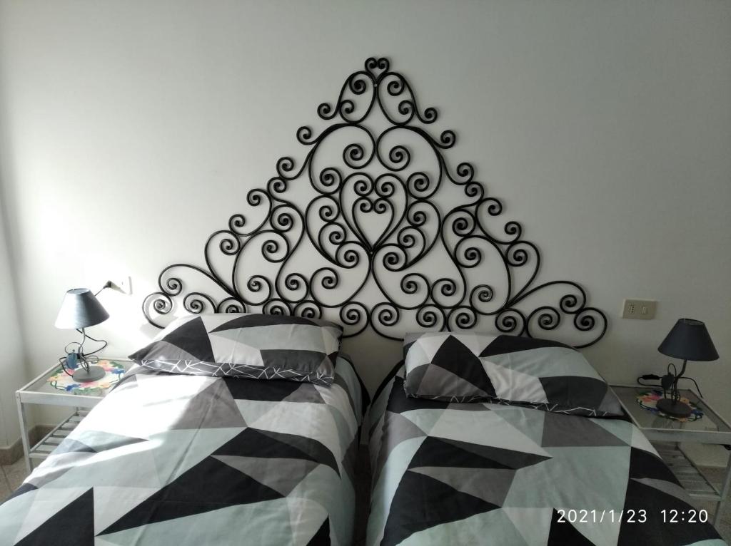 1 dormitorio con 1 cama con cabecero blanco y negro en Appartamento Marina, en Finale Ligure