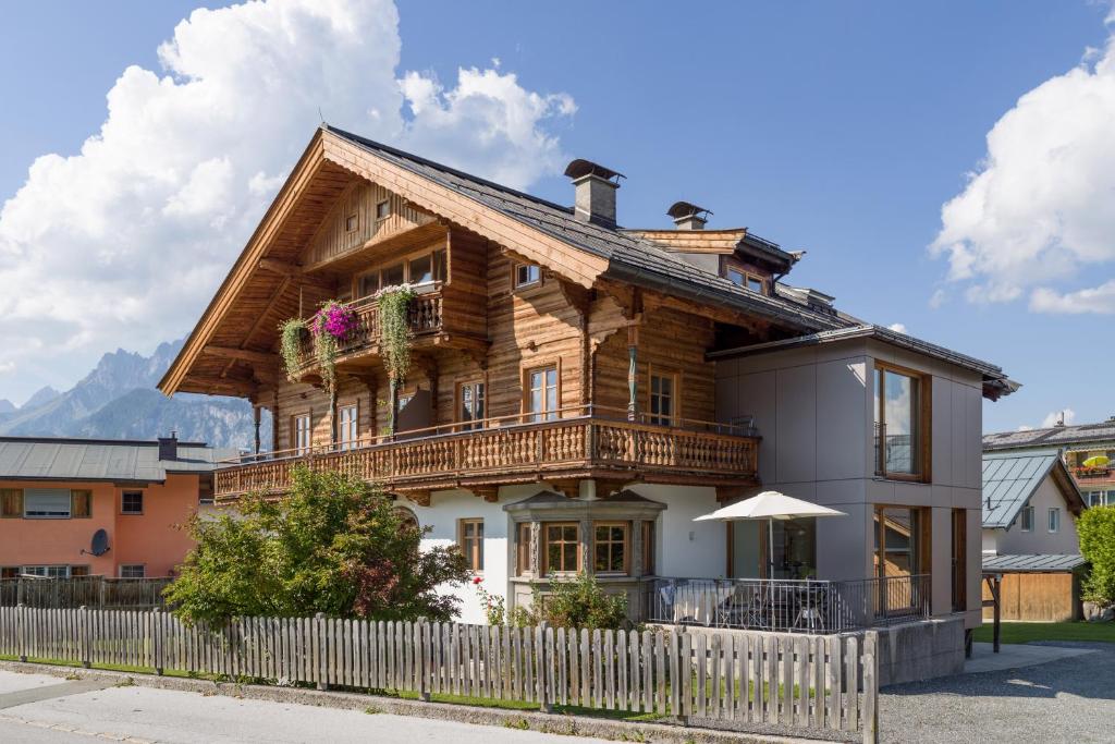 a wooden house with a balcony and a fence at Villa Grete, St. Johann in Tirol in Sankt Johann in Tirol
