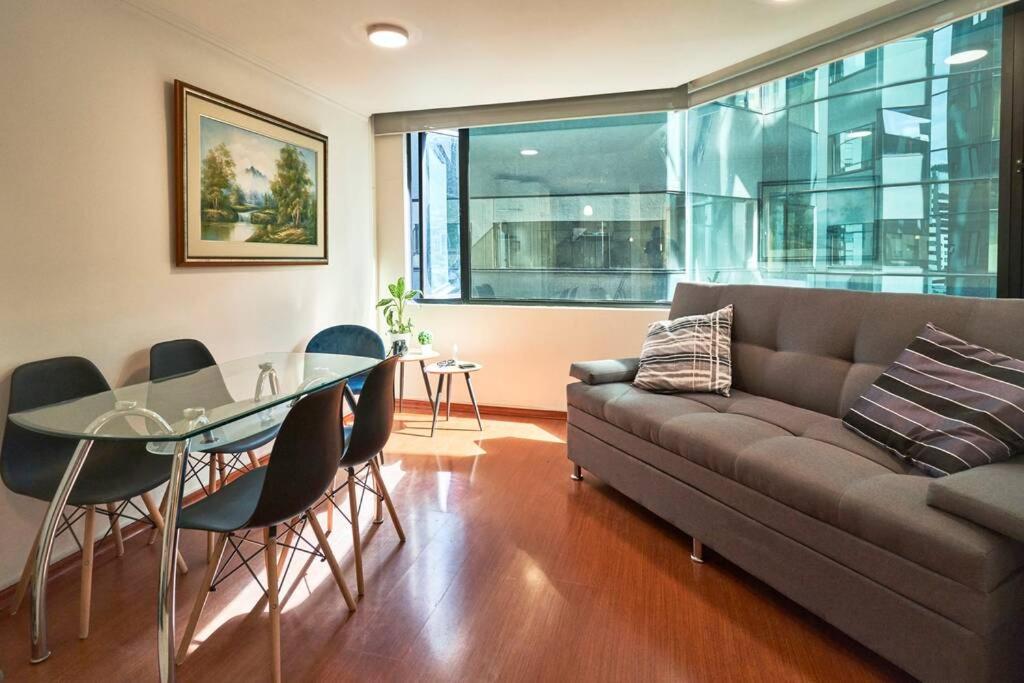 sala de estar con sofá y mesa de cristal en QuitoSuite Amoblada ubicación privilegiada en Quito