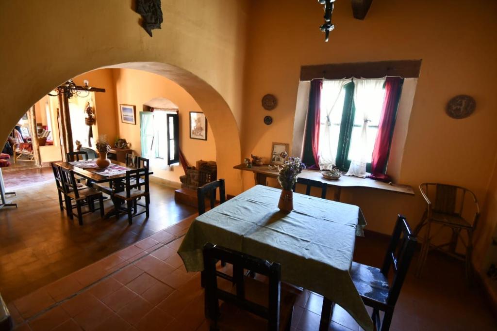 cocina y comedor con mesa y sillas en Hosteria la granja en Huacalera