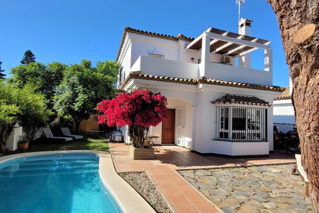 a villa with a swimming pool and a house at Chalet con piscina a 300 m del mar in Chiclana de la Frontera